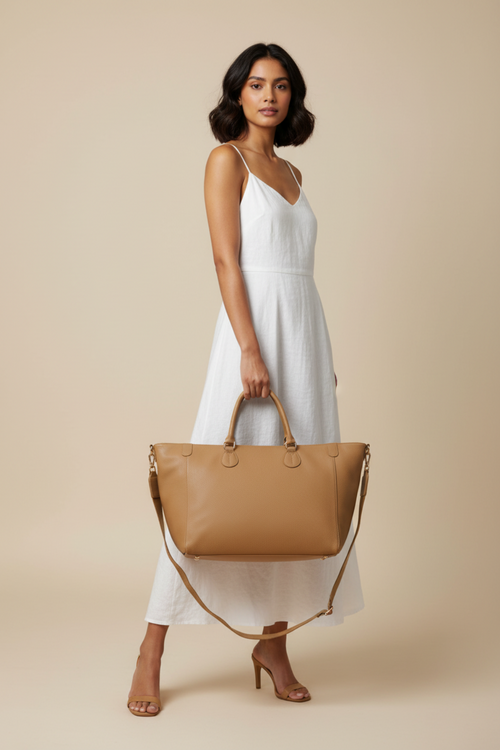 Studio shot of model holding smooth tan tote bag